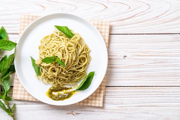 spaghetti met pestosaus, olijfolie en basilicumbladeren.