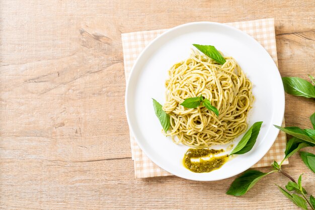 spaghetti met pestosaus, olijfolie en basilicumbladeren.