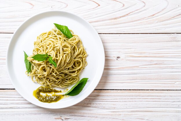 spaghetti met pestosaus, olijfolie en basilicumbladeren.