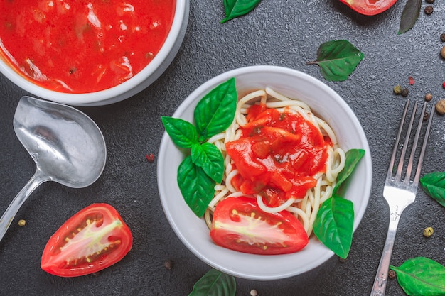 Spaghetti met saus in een bord met basilicumblaadjes