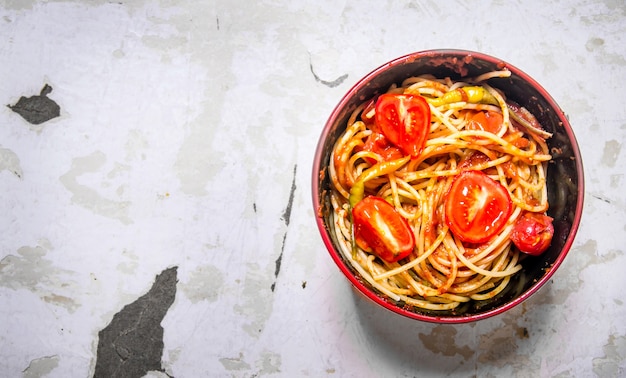 Spaghetti met tomatenpuree, kruiden en tomaten in een kom.