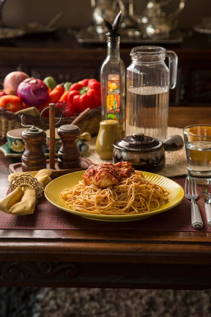 Spaghetti met tomatensaus en kipstoofpot Peru Peruaans comfort food mise en place houten tafel