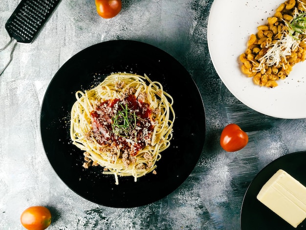 Spaghetti met tomatensaus, mozzarella kaas en verse basilicum in plaat op witte houten achtergrond