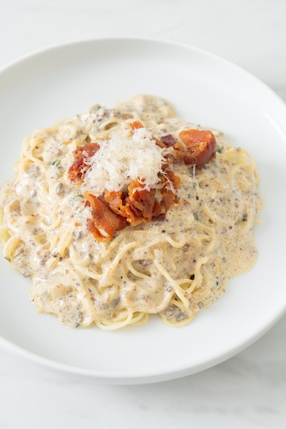 spaghetti met truffelroomsaus en champignon op bord