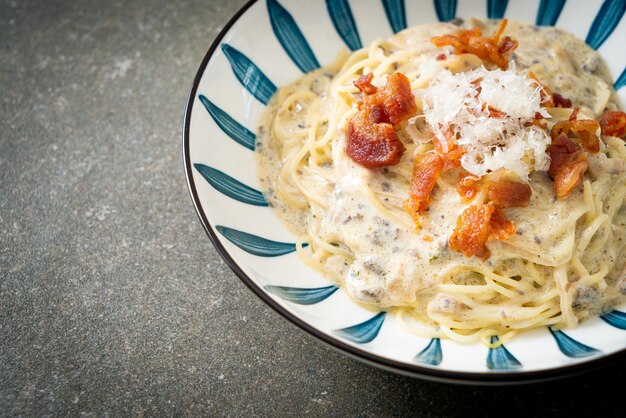 spaghetti met truffelroomsaus en champignon op bord