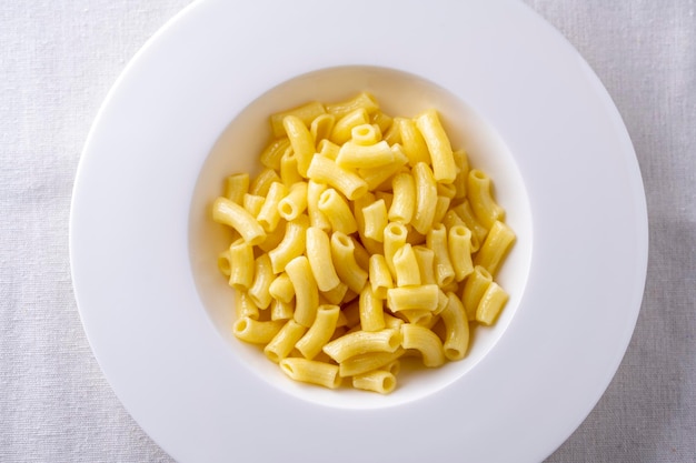 Spaghetti op een wit bord en een witte tafel