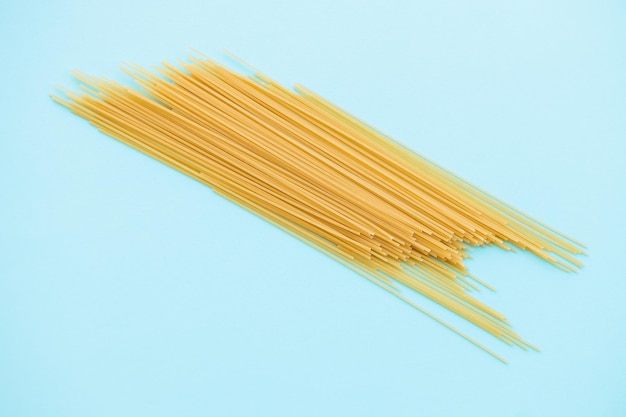 Spaghetti pasta on blue background from above