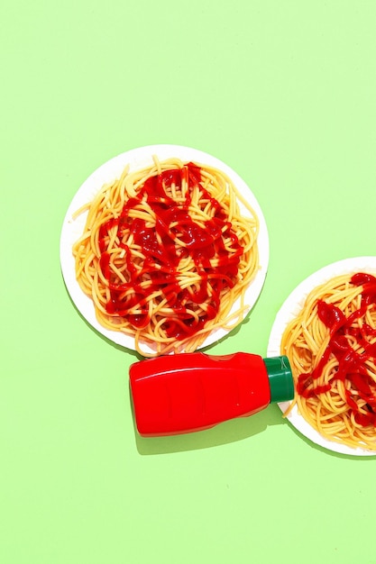 Spaghetti pasta met ketchup op groene achtergrond Minimalistisch dieet calorie Italiaans eten kunst concept