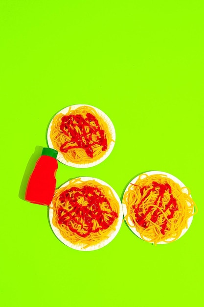 Spaghetti pasta met ketchup op groene achtergrond Minimalistisch dieet calorie Italiaans eten kunst concept