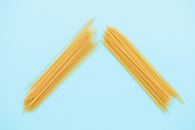 Spaghetti pasta op blauwe achtergrond van bovenaf
