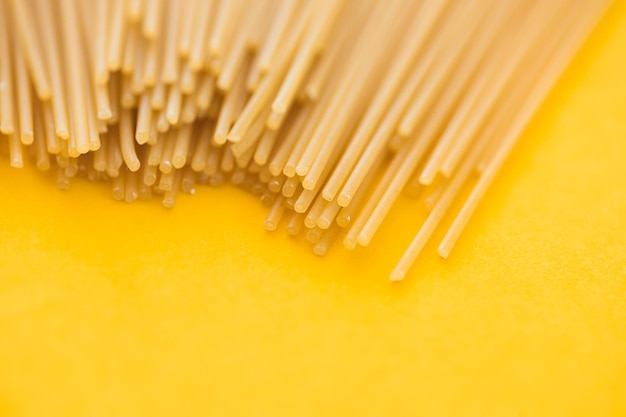 Spaghetti pasta op gele achtergrond van bovenaf