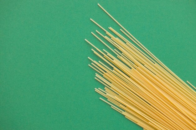 Spaghetti pasta op groene achtergrond van bovenaf