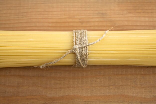 Spaghetti pasta tied with string on a wooden table The concept of cooking cuisine catering