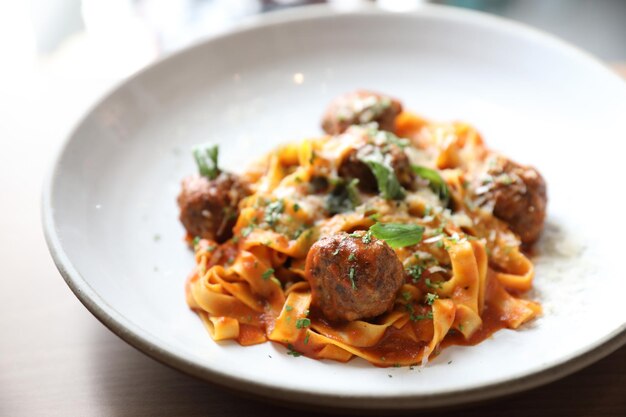 Spaghetti pasta with beef meatballs and tomato sauce on wood background . italian food