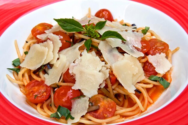 Spaghetti pasta with cherry tomatoes parmesan cheese and herbs Healthy vegan food concept