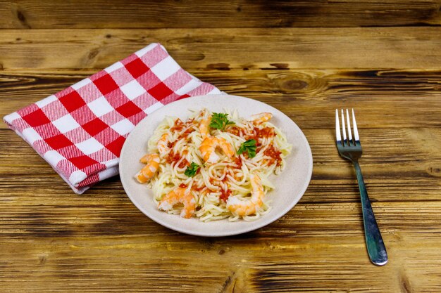 Spaghetti pasta with prawns tomato sauce and parsley on wooden table