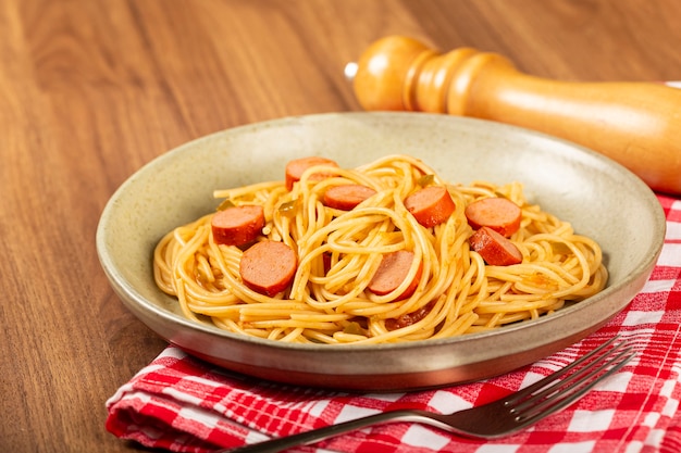 spaghetti pasta with sliced sausages and tomato sauce