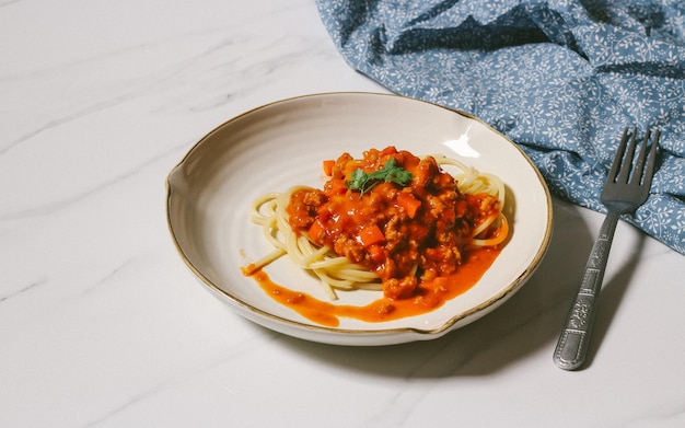 Макароны спагетти с томатным соусом в белой миске Белый мраморный фон Вид сверху Крупным планом
