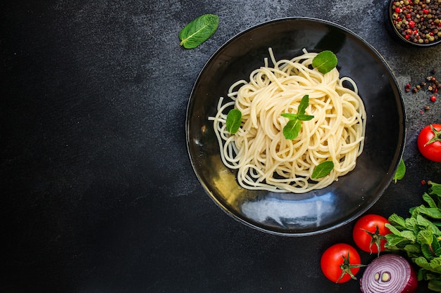 La pasta degli spaghetti con il pomodoro delle verdure mangia il piatto