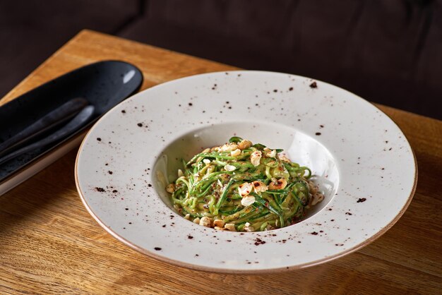 ズッキーニ、ヘーゼルナッツ、チーズのスパゲッティパスタ。ベジタリアン野菜パスタ。ズッキーニ麺。健康食品のコンセプト、選択的な焦点