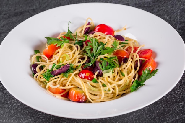 Spaghetti puttanesca spaghetti with black olives and cherry tomatoesxA