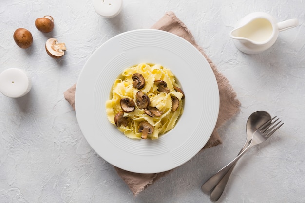 Spaghetti reginelle pasta with mushrooms on white. Tasty healthy dinner.