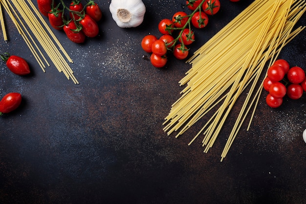 Spaghetti, tomato and garlic on the black table