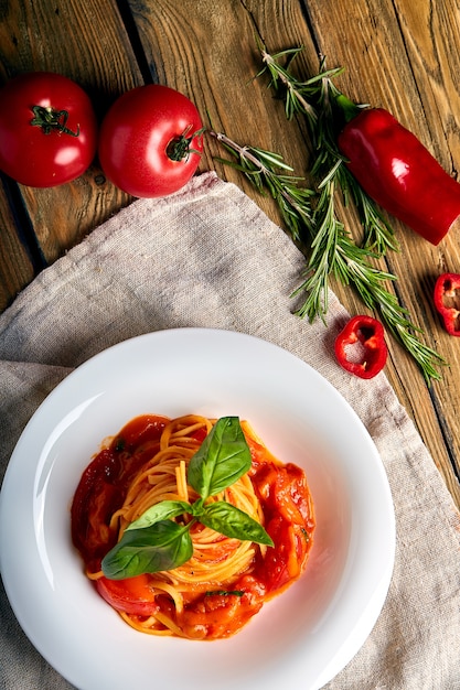 Basilico dei pomodori degli spaghetti su fondo di legno