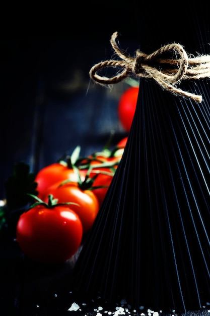 Spaghetti and tomatoes still life in low key selective focus