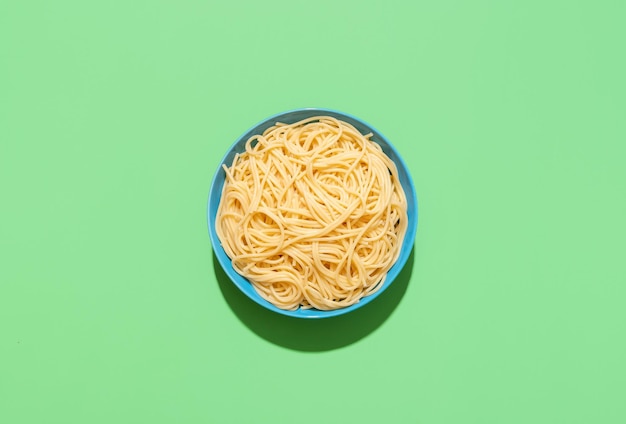 Spaghetti top view on a green background Cooked pasta without sauce