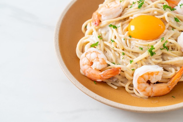 Photo spaghetti white cream sauce with shrimps and egg yolk