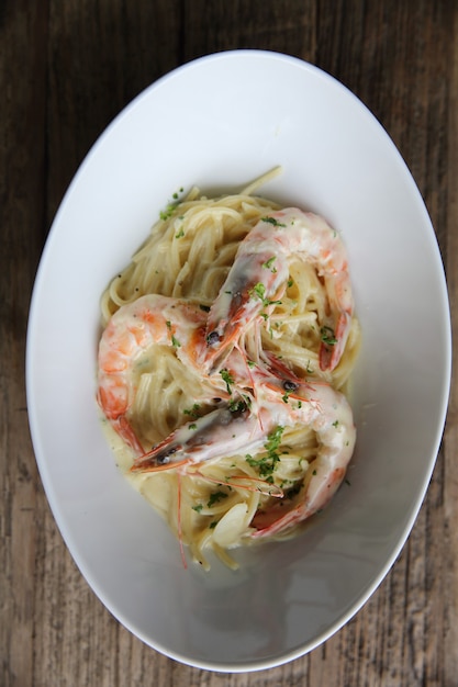 Spaghetti white sauce with shrimp on wood background