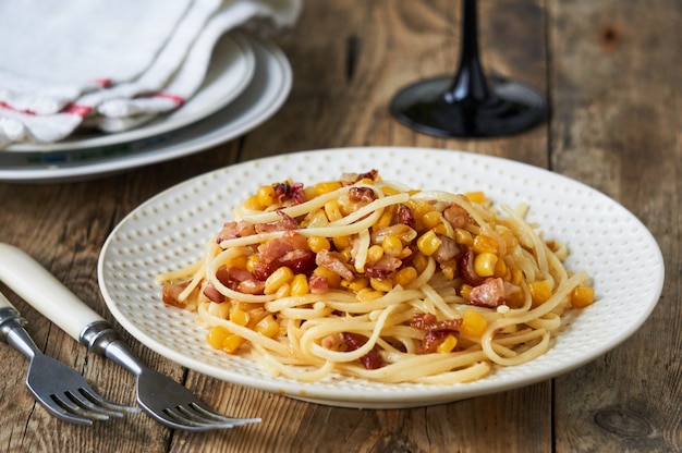 Spaghetti with bacon and corn on a plate