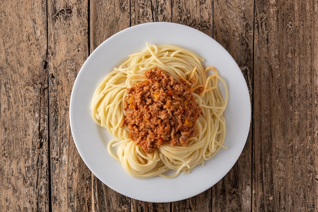 Spaghetti with bolognese sauce on wooden table