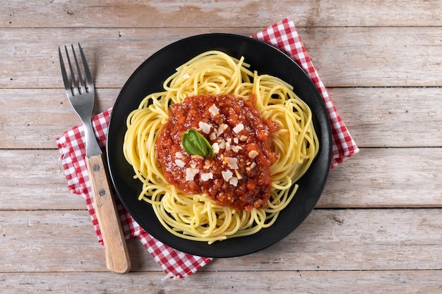 Spaghetti with bolognese sauce on wooden table