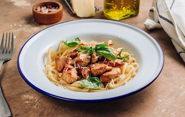 Spaghetti with chicken and basil on a plate