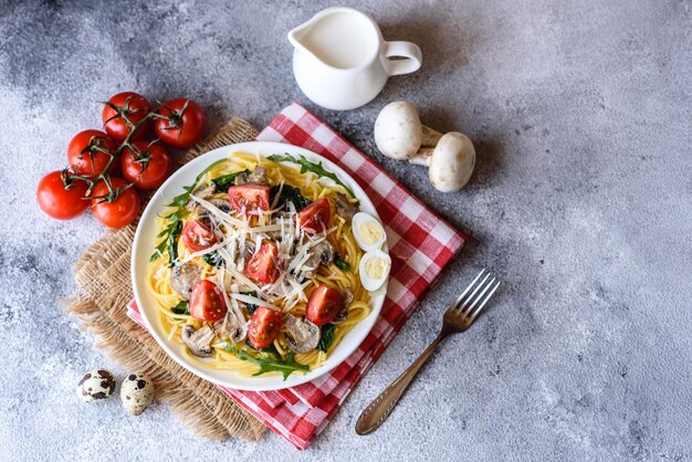 Photo spaghetti with mushrooms cheese spinach rukkola and cherry tomatoes italian dish mediterranean culture