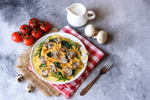 Spaghetti with mushrooms, cheese, spinach, rukkola and cherry tomatoes. Italian dish, Mediterranean culture