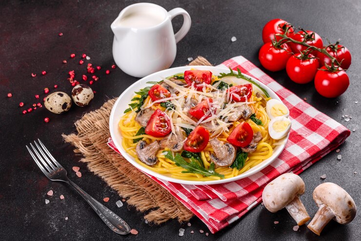 Фотография спагетти с грибами, сыром, шпинатом, рукколой и помидорами черри. итальянское блюдо, средиземноморская культура