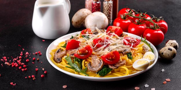 Photo spaghetti with mushrooms cheese spinach rukkola and cherry tomatoes