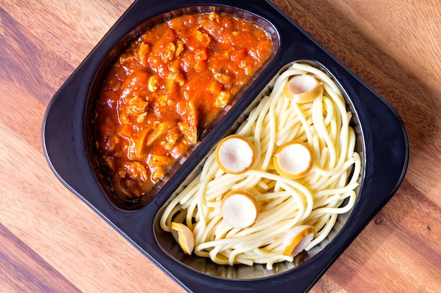 Spaghetti with red tomato sauce in a plastic box