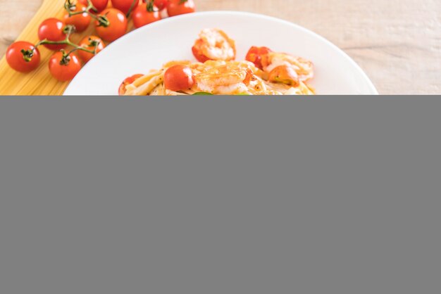 Foto spaghetti con gamberetti, pomodori, basilico e formaggio