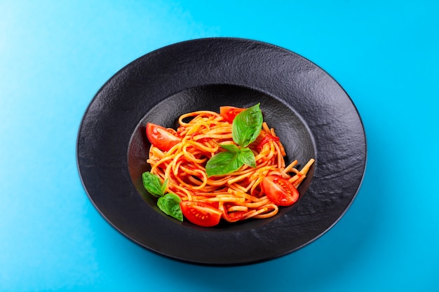 Spaghetti with tomato sauce, basil leaves, cherry tomatoes