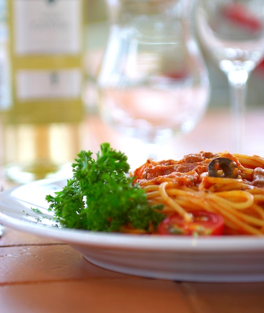 Spaghetti with a tomato sauce on a table in cafe.
