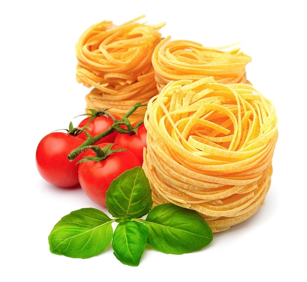 Spaghetti with vegetables and basil on white