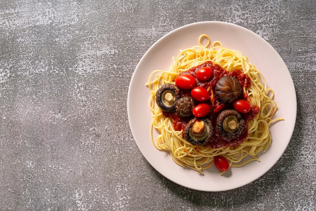 spaghettiSpaghetti bolognese in een wit bord op een lichte ondergrond van betonsteen of leisteen