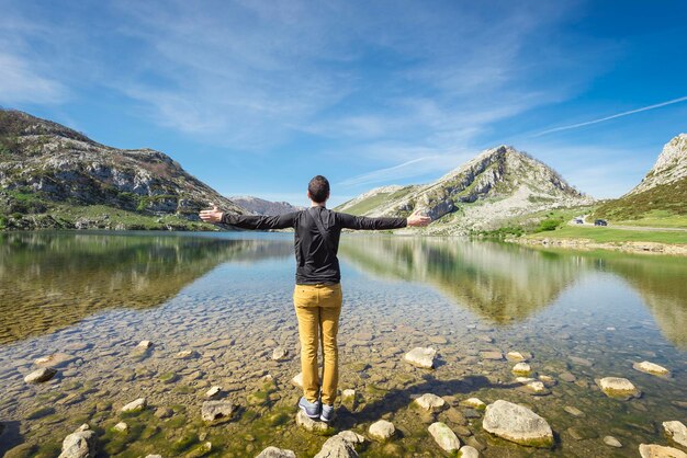 Spain, Asturias, Picos de Europa National Park, man standing with raised arms at Lakes of Covadonga