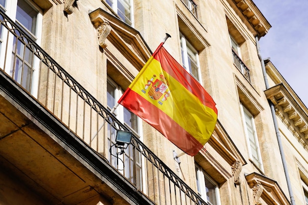 Foto bandiera della spagna sventola davanti al classico sfondo ufficiale dell'edificio