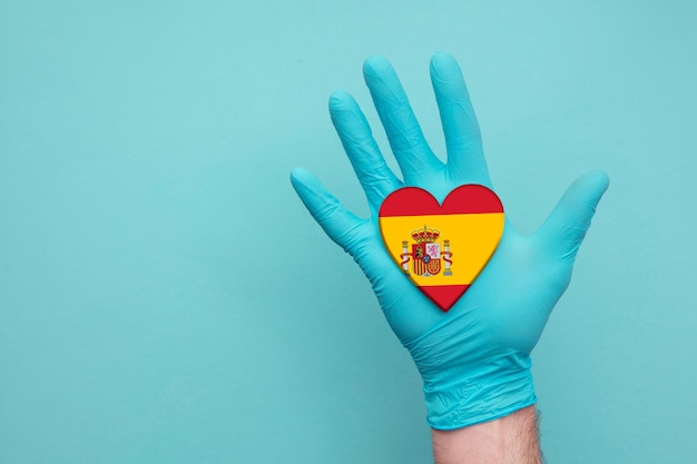 Foto spagna salute medica cuore infermiera mano che tiene bandiera del cuore del paese