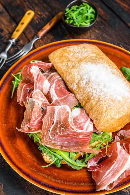 Spanish bocadillo de jamon, serrano ham sandwich on ciabatta bread with arugula. 